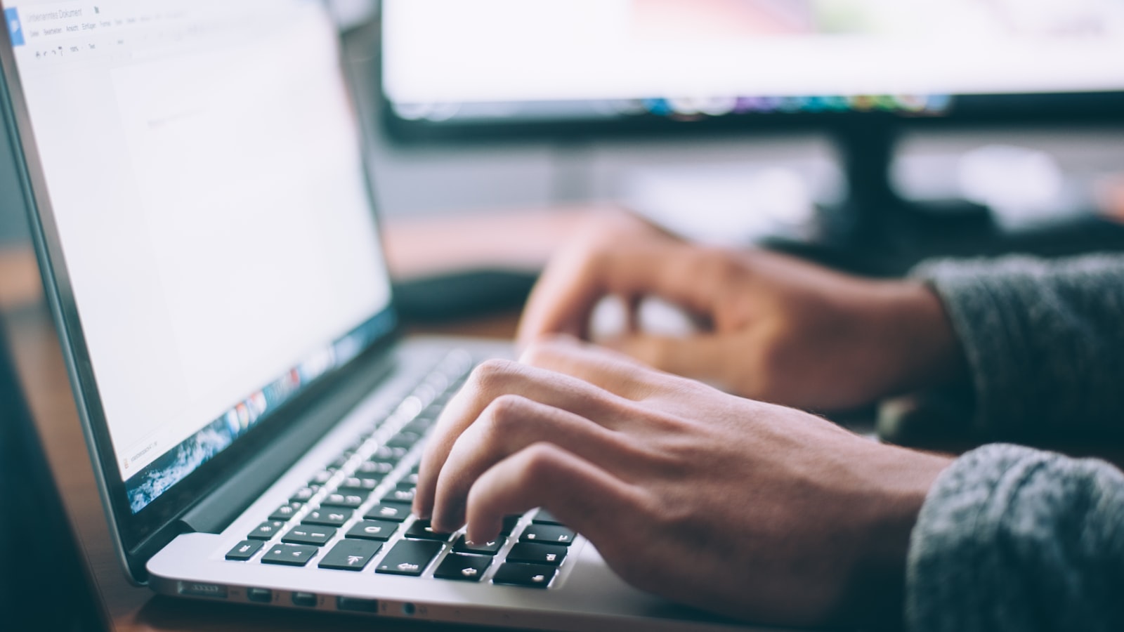 A laptop, notebook, and coffee on a wooden desk - the lean office setup most service businesses actually need before buying software.