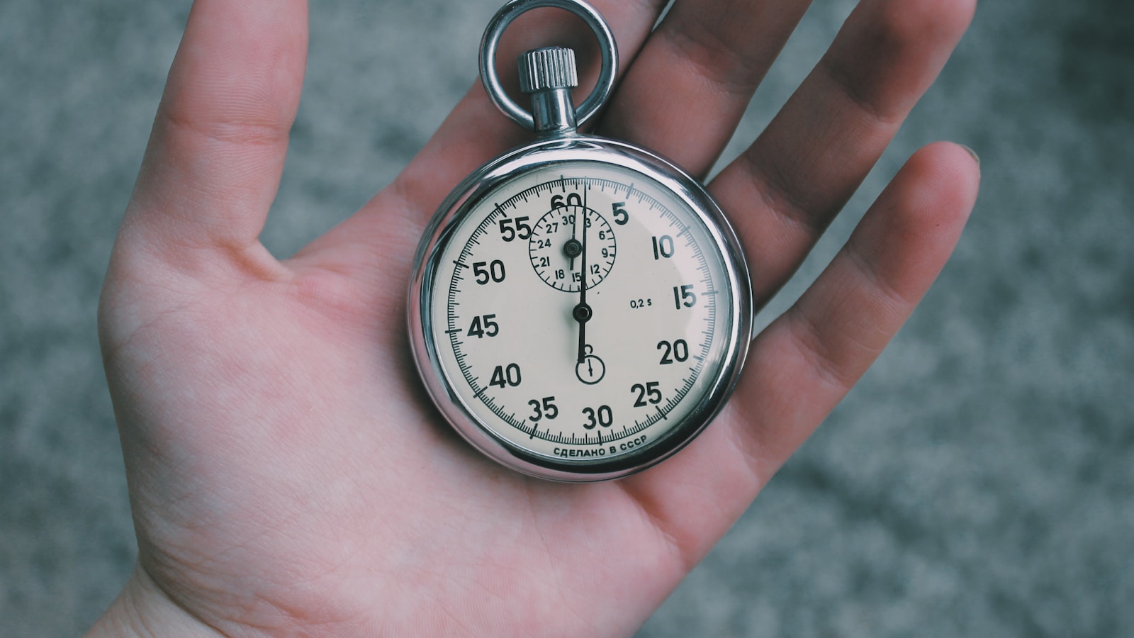 A hand holding a stopwatch frozen at the start position - a visual cue for the speed-versus-price thesis of the article.